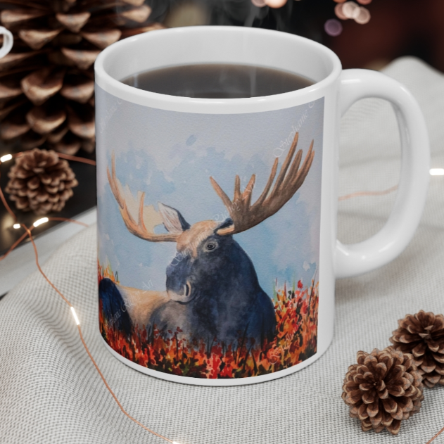 Large moose sitting on a bed of fall foliage watercolor art. Featured on an 11 oz mug.