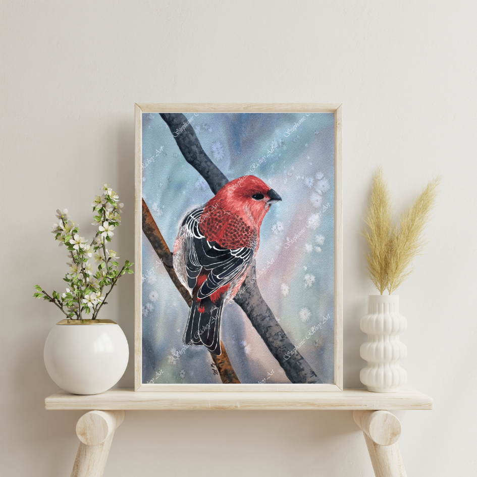 A vibrant illustration of a red bird perched on a branch, displayed in a wooden frame against a soft blue background. The scene is accentuated by decorative flowers and plants on a wooden shelf.